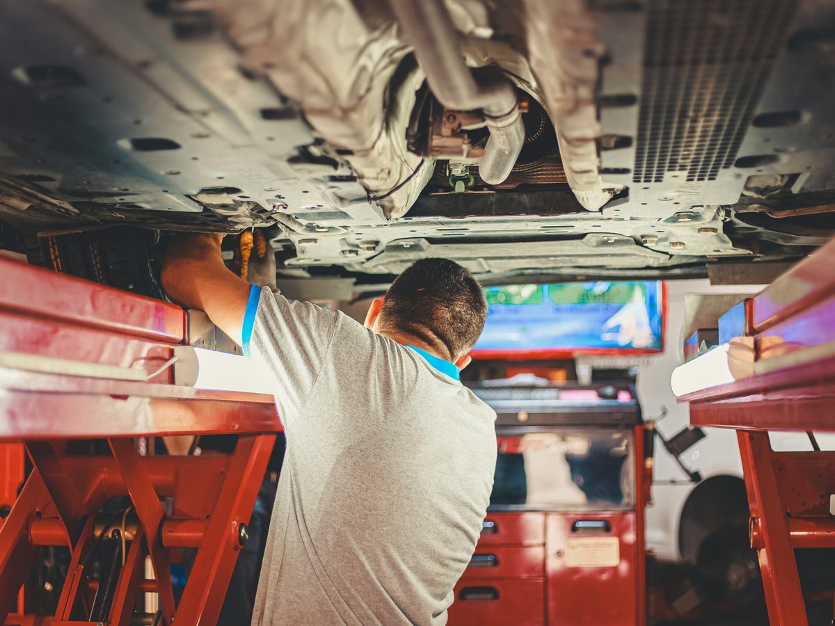 Technician working under a vehicle on a lift